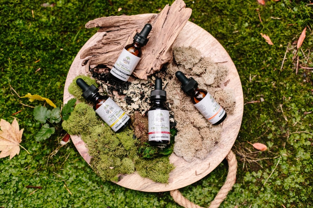 product photo of several different bottles of a product lying on a wooden plate